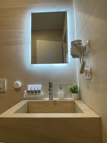 a bathroom with a sink with a mirror at Solea Hotel in Vlorë