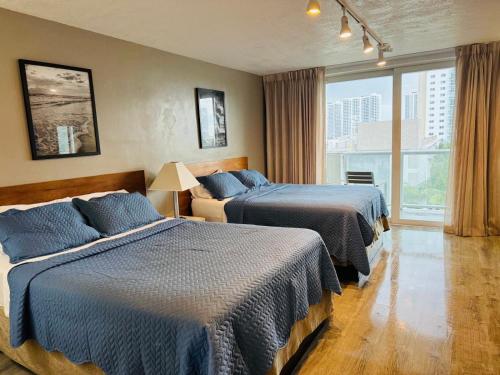 a hotel room with two beds and a window at Renovated Beachfront Condo with Balcony in Sunny Isles Beach