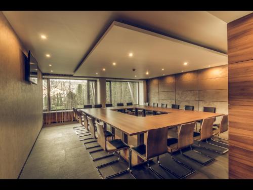 a conference room with a large wooden table and chairs at Hotel Oscar in Campina