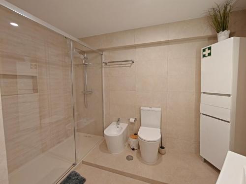 a bathroom with a toilet and a glass shower at 2F Sao Gabriel - Casas & Papeis in Armação de Pêra