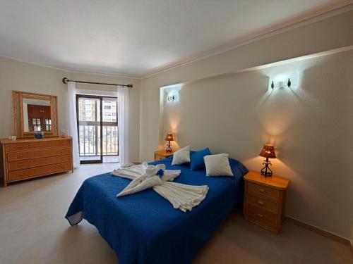a bedroom with a blue bed with towels on it at 2F Sao Gabriel - Casas & Papeis in Armação de Pêra