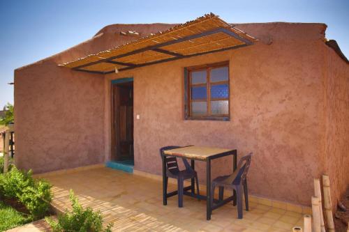 a table and chairs in front of a house at Dômes et Bangalows traditionnel in Marrakesh