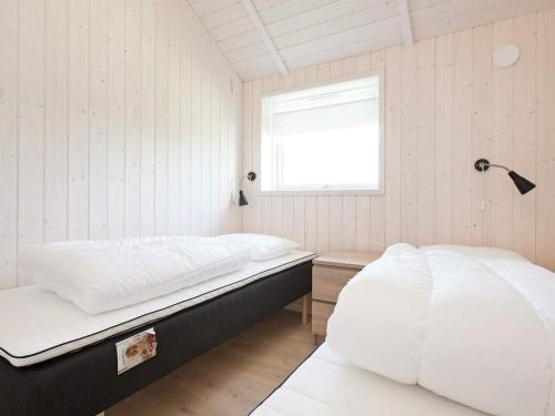 a bedroom with two beds and a window at Luxury Retreat with Spa - By Traum Ferienwohnungen in Bøtø By