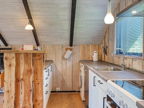 a kitchen with wooden walls and a sink and a counter at 5 person holiday home in Dannemare in Dannemare