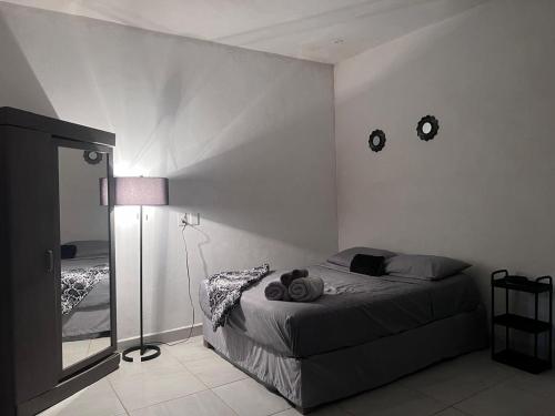 a bedroom with a bed and a lamp and a mirror at La Isla Studio - Quimixto in Qumiste