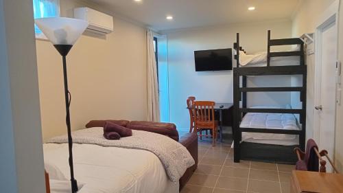 a bedroom with a bed and a bunk bed at The Central Apartment in Geraldine