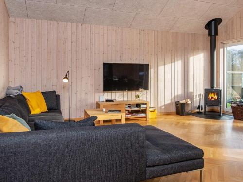 a living room with a couch and a flat screen tv at 5 star holiday home in Haderslev in Haderslev
