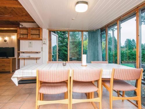 a dining room with a table and chairs and windows at 7 person holiday home in Kolind in Kolind