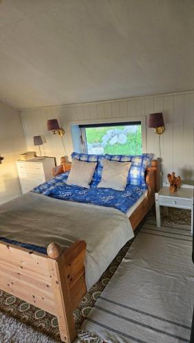 a bedroom with a large bed with a large window at Fjordhuset på Helgelanskysten in Leirfjord