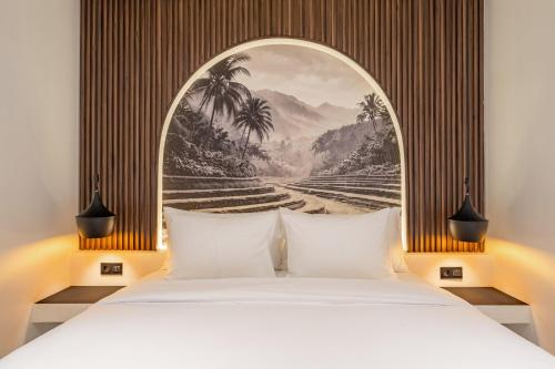 a bedroom with a bed and a painting of palm trees at Avida Studios in Uluwatu - 5 mins walk to Thomas Beach in Uluwatu