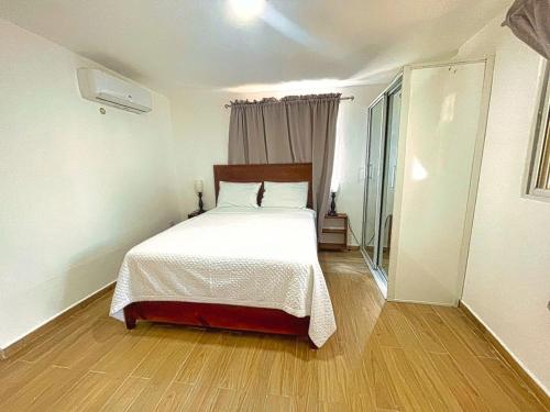 a bedroom with a large bed with a wooden floor at Villa La Dueña Las Terrenas in Las Terrenas