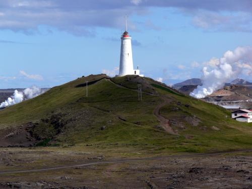 a large white clock tower on top of a hill at Reykjanes Guesthouse in Grindavík