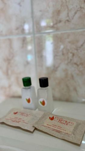 two bottles of toiletries sitting on a bathroom sink at Hotel Premium Real in Medellín