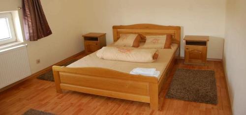 um quarto com uma cama de madeira e duas mesas de cabeceira em Pensiunea Rodica em Nadlac