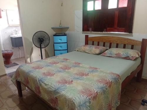 a bedroom with a bed and a fan at Refúgio familiar in Belém