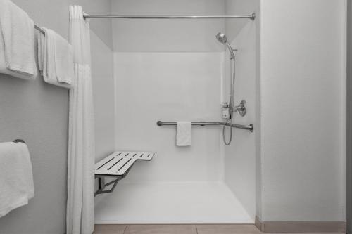 a shower stall with a bench in a bathroom at Holiday Inn Express Marble Falls by IHG in Marble Falls
