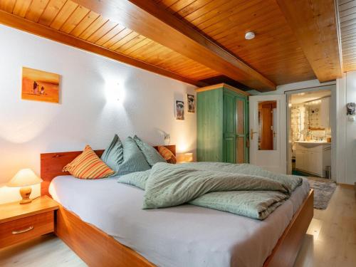 a bedroom with a large bed with a wooden ceiling at Bühelhus in Dalaas