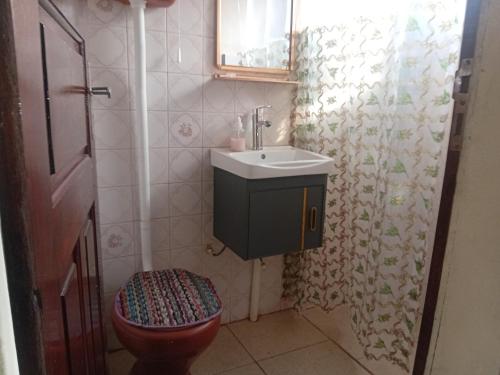 a small bathroom with a toilet and a sink at Refúgio familiar in Belém