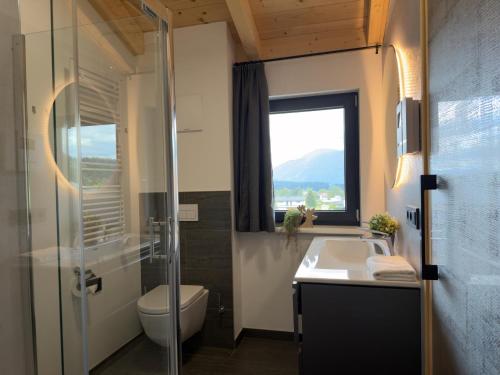 a bathroom with a sink and a toilet and a window at Obermöschach 1 in Lake Pressegg
