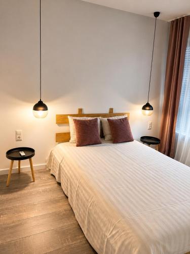 a bedroom with a large white bed with two lamps at Vila Dar Selam halal-friendly in Mostar