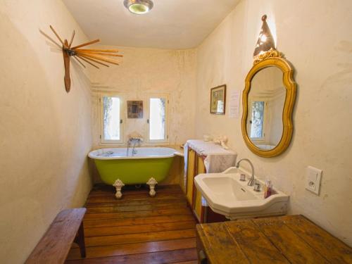 a bathroom with a green tub and a sink at Le Serre des Granges Plus in Montaulieu