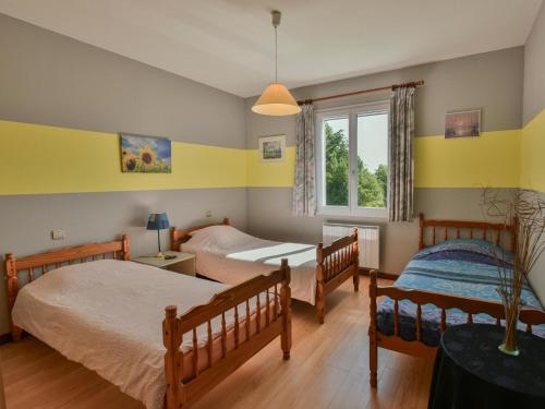 two beds in a room with yellow walls at Grande Gite Bassoues in Bassoues