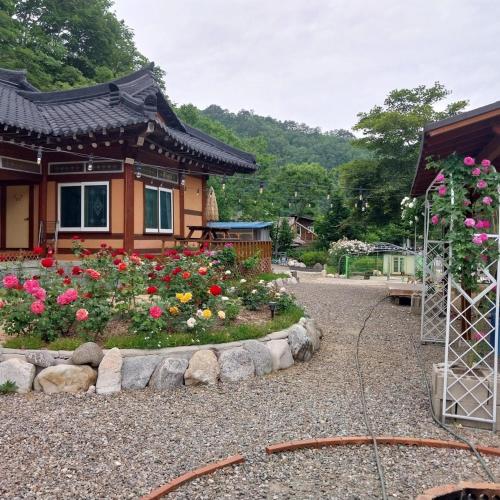 a garden with flowers in front of a house at Yangyang Haneul Cheon Ddaji in Yangyang