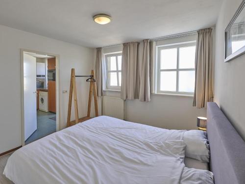 a bedroom with a bed and two windows at De open schuur in Elsendorp