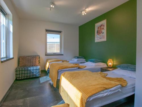 three beds in a room with green walls at Landzicht in Haps