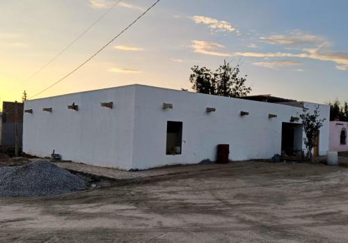 a white building with two doors and a sky at Tu hostalito en Parras in Santa Isabel
