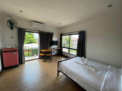 a bedroom with a bed and a desk and windows at The Connect Chiang Mai in Chiang Mai
