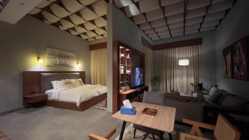 Orien chalet في Abū Nukhayl: غرفة نوم بها سرير وغرفة معيشة