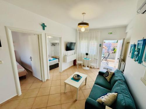 a living room with a couch and a room with a bed at MG Sea View Apartments & Private Parking in Pefkochori