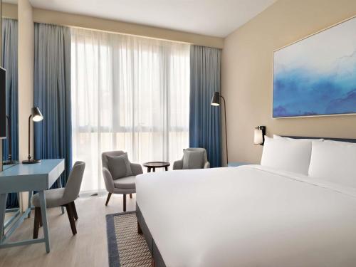 a hotel room with a bed and a desk at Mercure Dubai Deira in Dubai