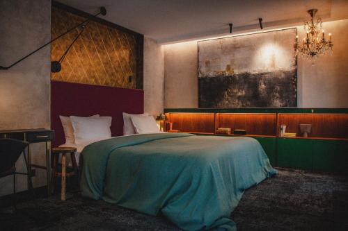 ein Schlafzimmer mit einem Bett und einem Kronleuchter in der Unterkunft Unique Boutique Hotel Antibes Juan-les-Pins in Juan-les-Pins