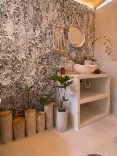 a bathroom with a sink and a mirror on a wall at Exotic private glamping in Nusa Penida