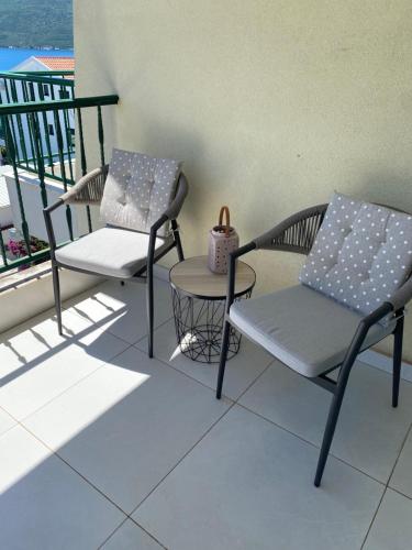 two chairs and a chair on a balcony at Adriadome Sky in Bijela