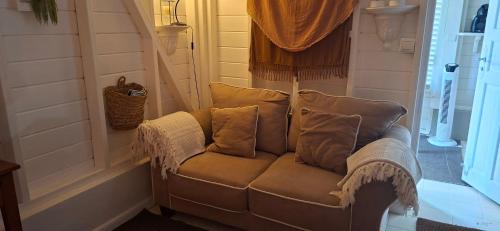 a couch with pillows on it in a room at Les Gîtes de Bergette in Petit-Bourg