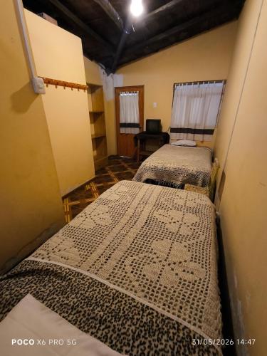 a room with two beds in a room at Casa de Turistas La Rinconada in Chacas