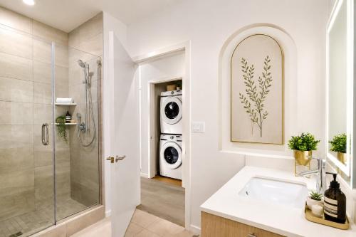 a bathroom with a sink and a washing machine at Splendid Executive Suites in Long Beach