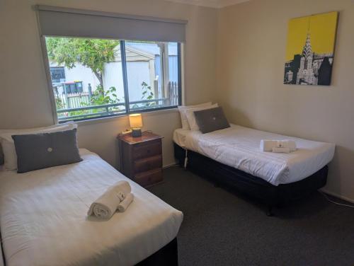 two beds in a room with a window at Riverside Golf Club in Gol Gol