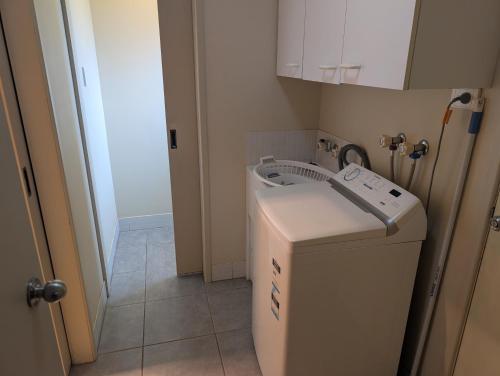 a laundry room with a washing machine and a cabinet at Riverside Golf Club in Gol Gol