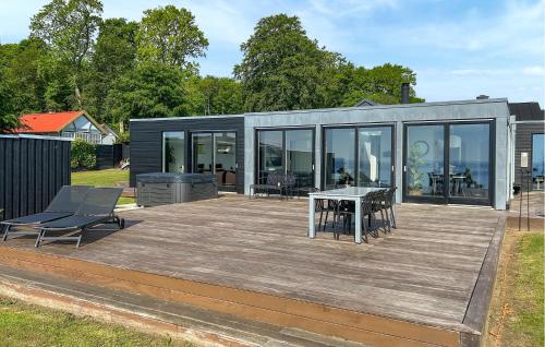 a house with a deck with a table and chairs at Lovely Home In Haderslev With Sauna in Haderslev