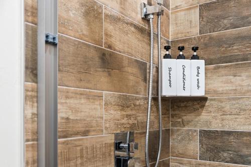a bathroom with two shampoo bottles on a wall at Glacier Luxury Retreat Oak Tree Apartment 3 in Hungry Horse