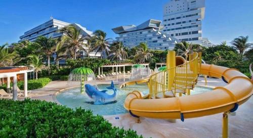 a water slide in a pool in a resort at Beachfront Getaway Condo in Cancún