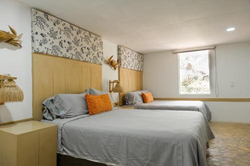 ein Schlafzimmer mit zwei Betten und einem Fenster in der Unterkunft Hotel Isla Real in Tierra Bomba