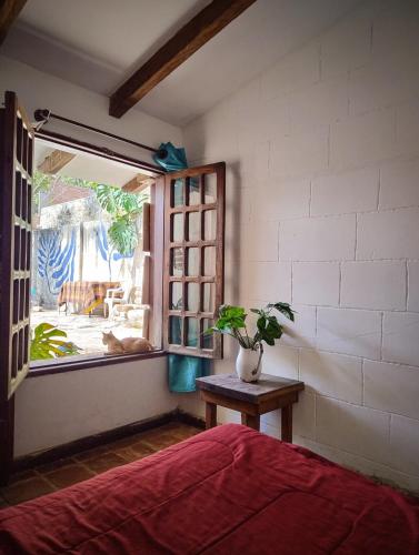 a bedroom with a bed and a window and a table at Casa Alquimia Completa in Samaipata