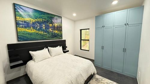 a bedroom with a bed and a painting on the wall at Glacier Luxury Retreat Montana Sky Apartment 2 in Hungry Horse