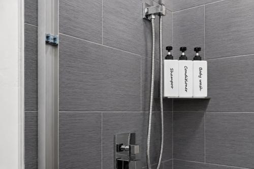 a shower with two shampoo bottles on a wall at Glacier Luxury Retreat Montana Sky Apartment 2 in Hungry Horse