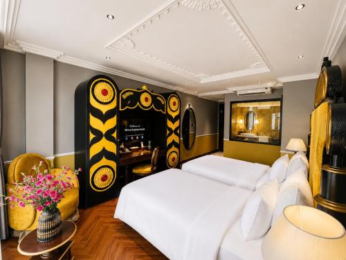 a bedroom with a large white bed and a desk at Eliana Robusta Hotel in Hanoi